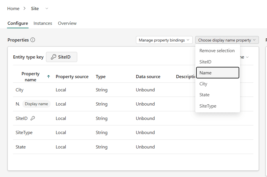 The Choose display name property dropdown open on the Site entity type, with Name highlighted, while the properties table below shows a Display name badge on the Name row and a key icon on SiteID